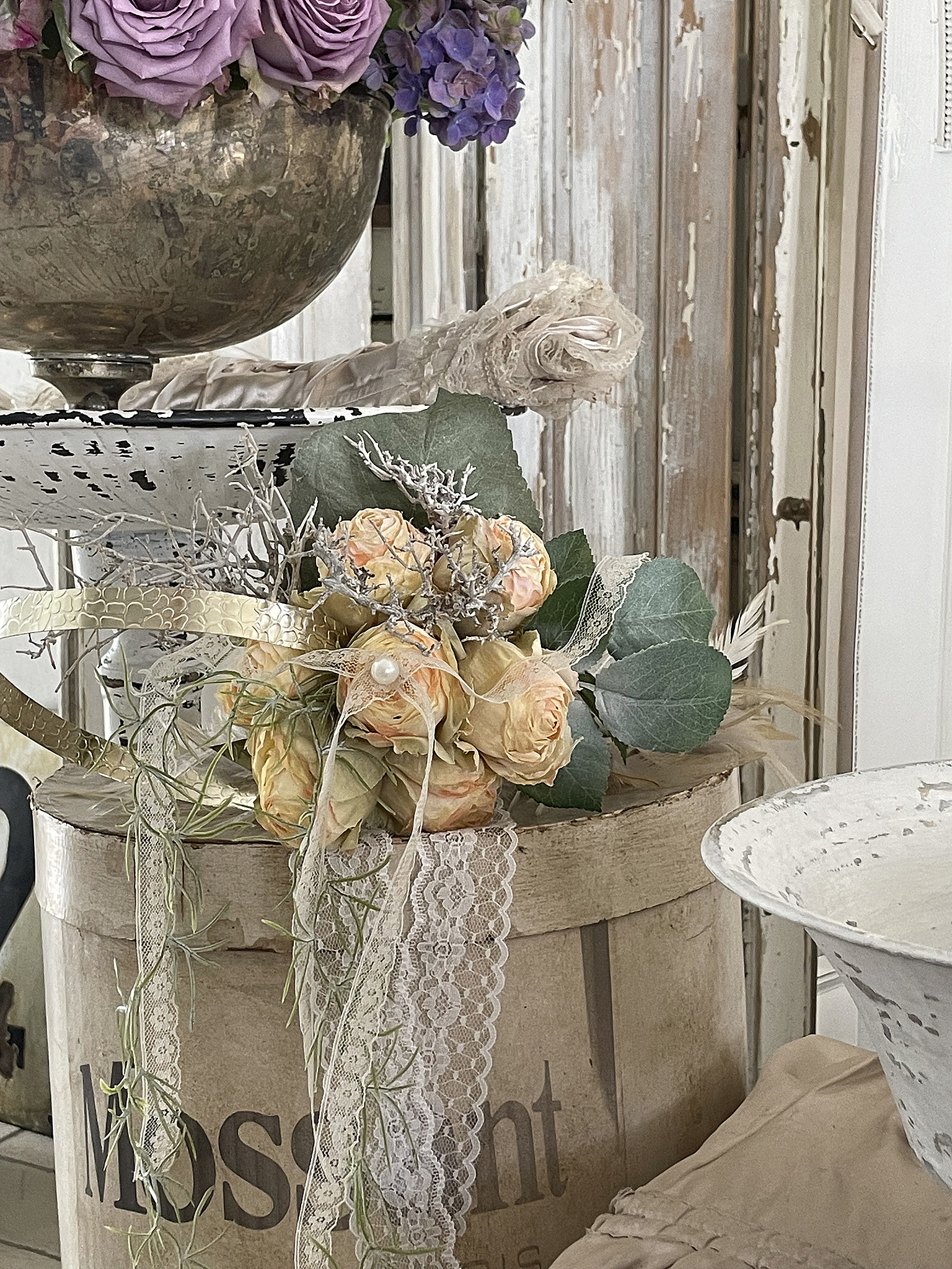 Dekorative Blumenarrangement mit Rosen und Spitze Schönes Blumenarrangement mit rosa und lilafarbenen Rosen, dekoriert mit Spitze und Eukalyptus.
