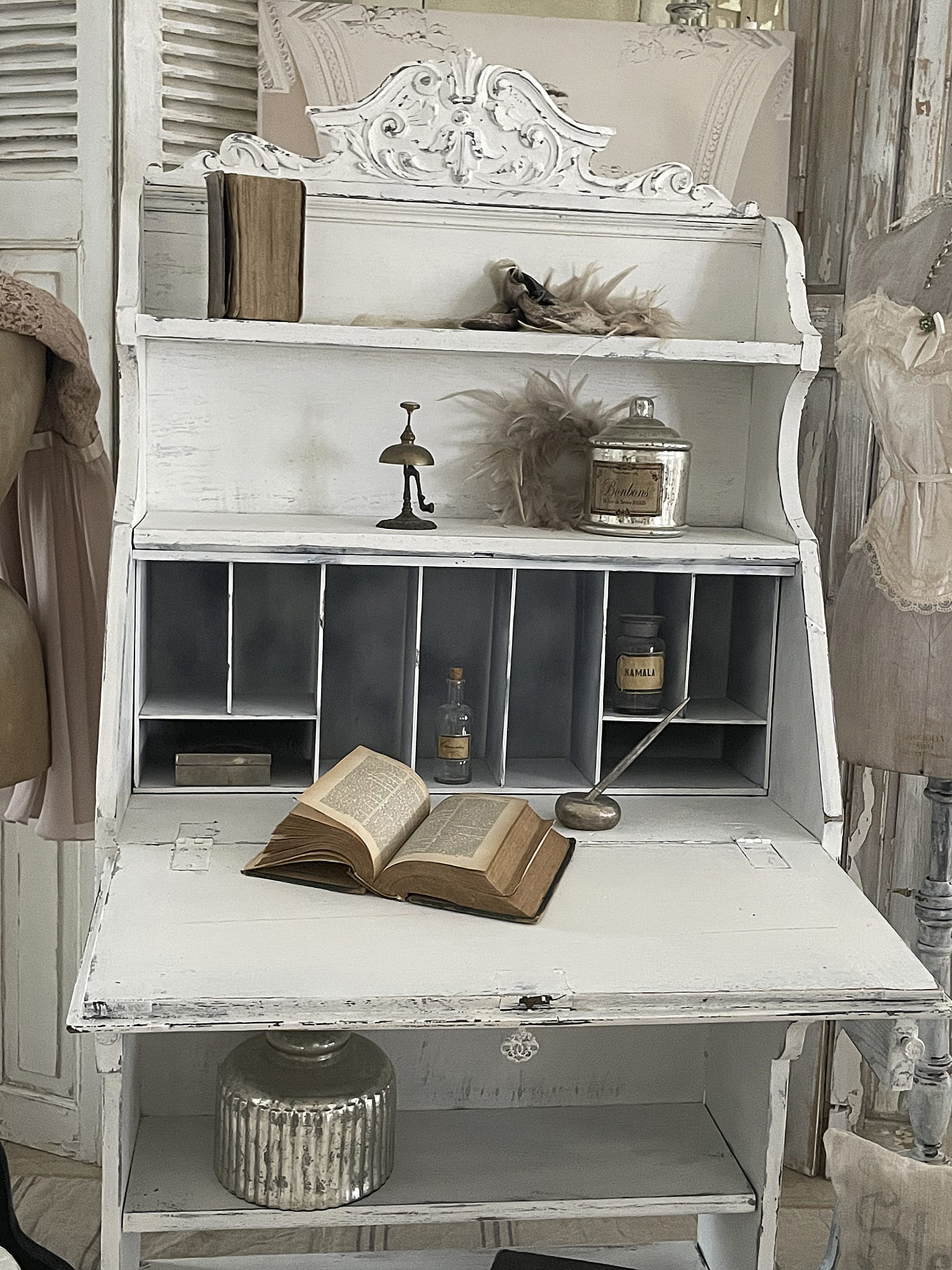Vintage Schreibtisch mit offenem Buch und dekorativen Accessoires Detailansicht eines antiken Schreibtisches mit einem offenen Buch, einer dekorativen Lampe und weiteren stilvollen Objekten.