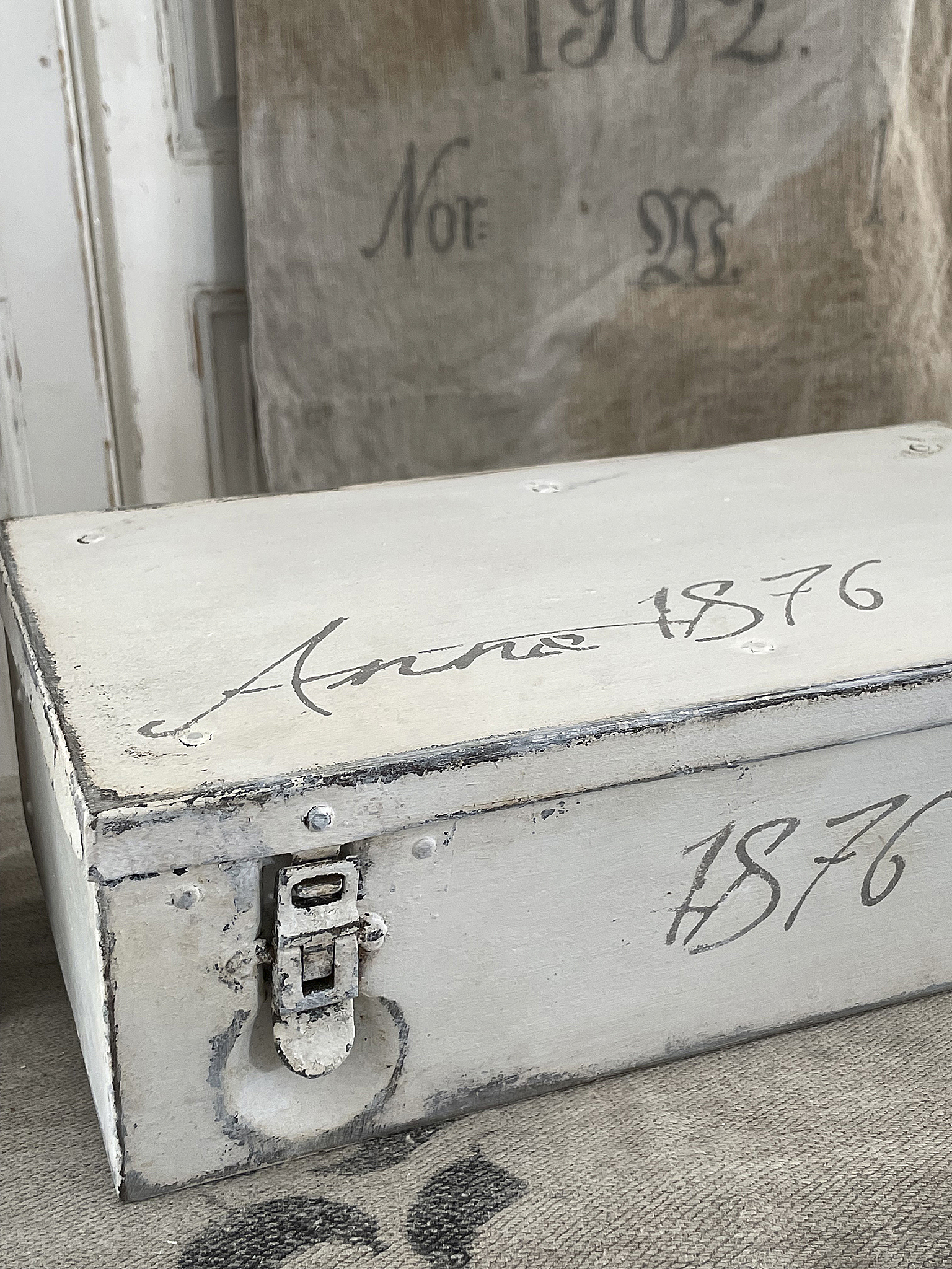Detailaufnahme einer antiken Holztruhe mit der Inschrift 1876 und einem Schloss