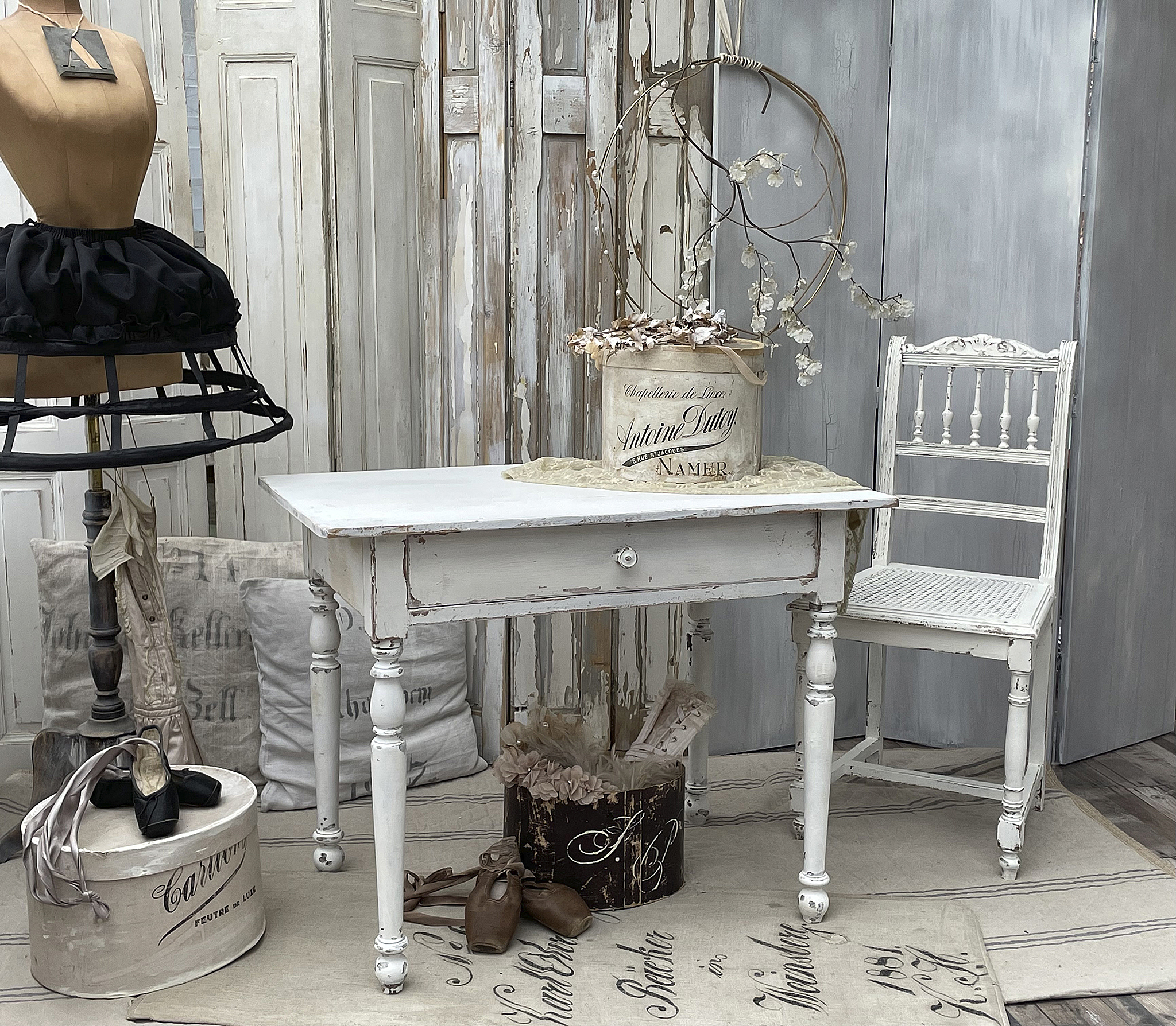 Vintage Holztisch mit Stühlen und Dekoration im Shabby Chic Stil Ein eleganter, vintage Holztisch mit einer dekorativen Blumenschale und Stühlen im Shabby Chic Stil.