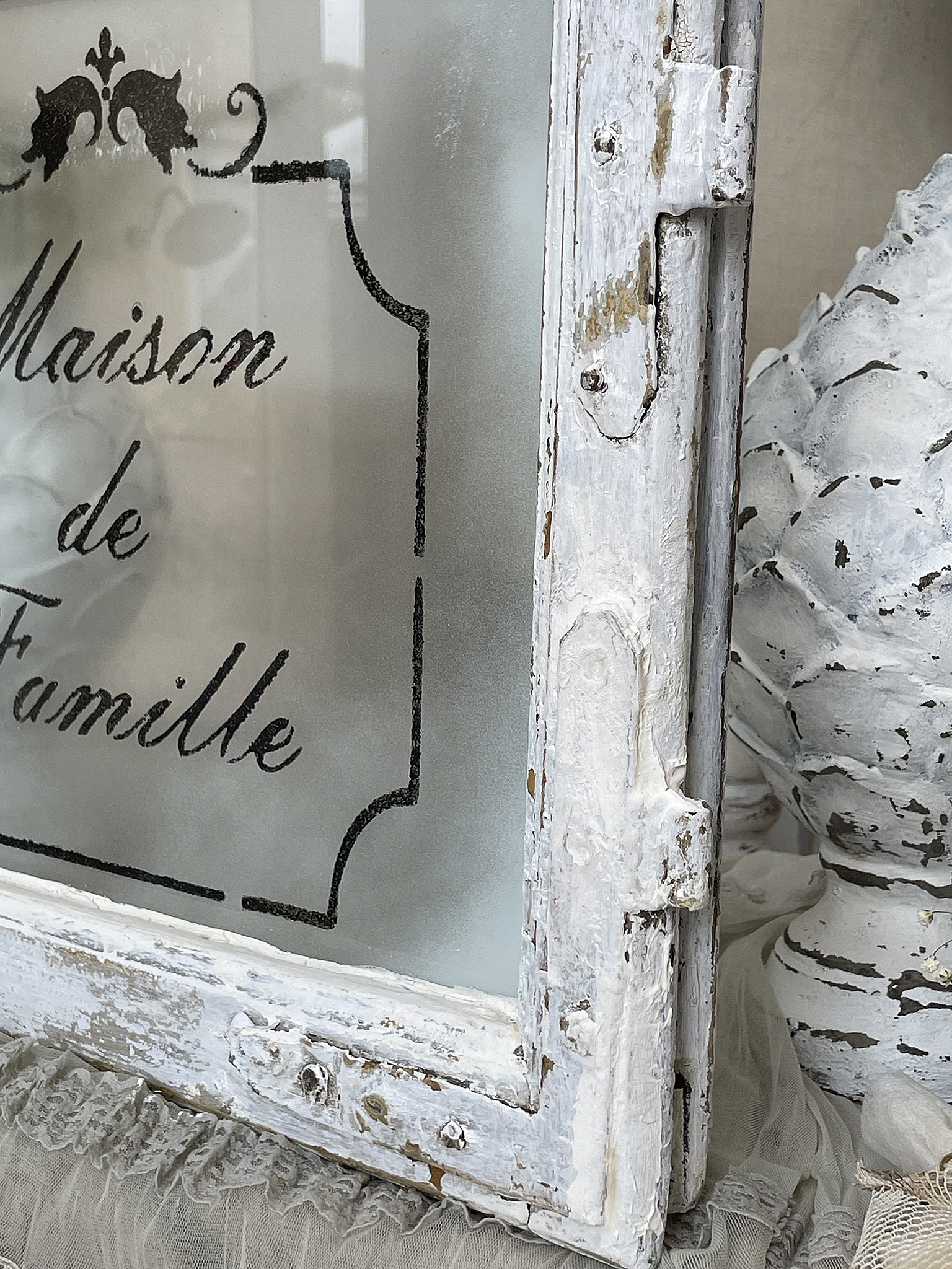 Vintage Fensterrahmen mit frosted Glas und Schriftzug Maison de Famille Dekorativer vintage Fensterrahmen mit frosted Glas und dem Schriftzug Maison de Famille.