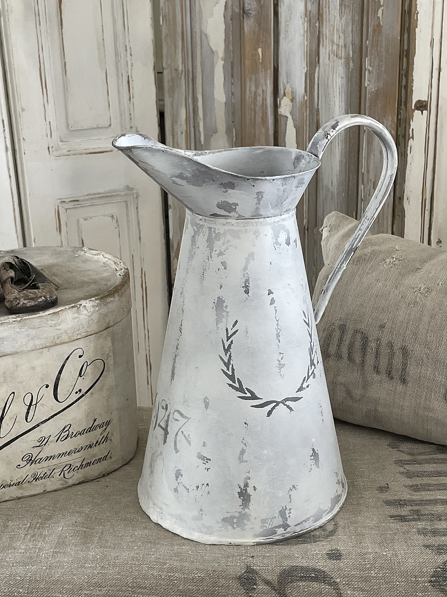 Dekorative weiße Metallkanne mit Patina Hübsche antike Metallkanne in Weiß mit einem strengen Design und dekorativen Details