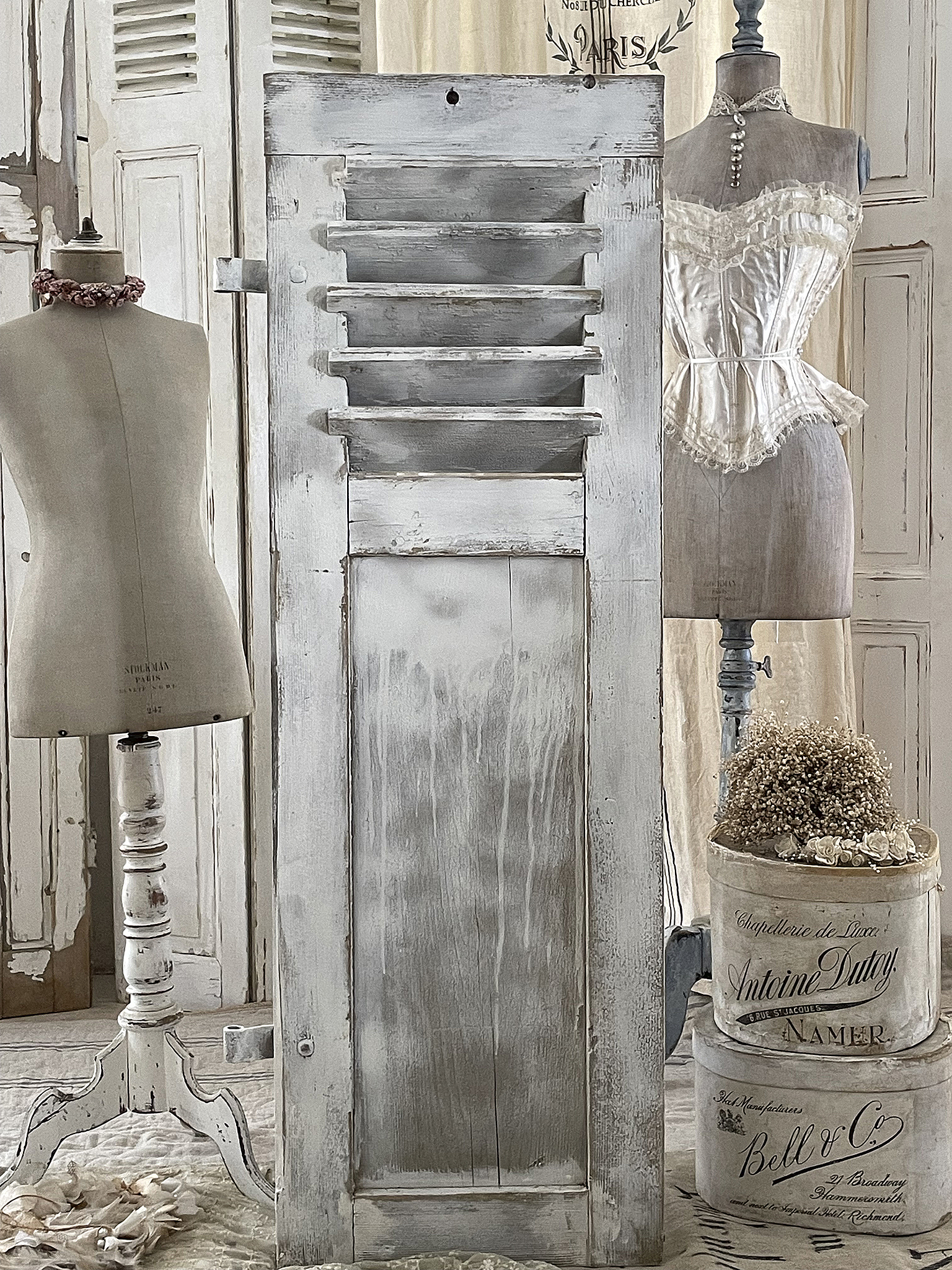 Antiker Holzschrank mit romantischem Stil und Dekoration Dekoratives Bild eines antiken Holzschranks in einem romantisch eingerichteten Raum mit Mannequins und Vintage-Accessoires.