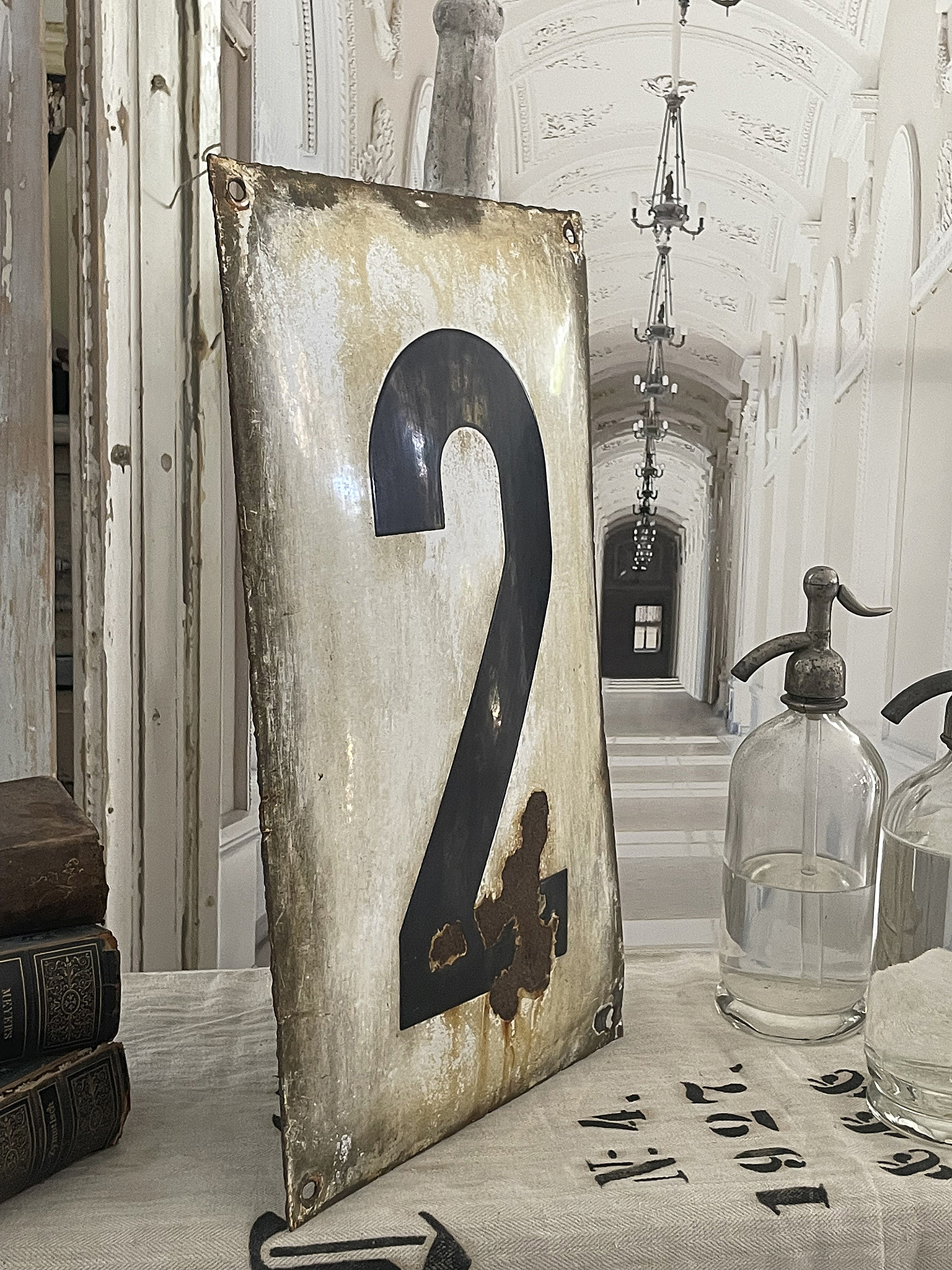 Das antike Schild mit der Nummer 2 steht in einem elegant gestalteten, historischen Raum.